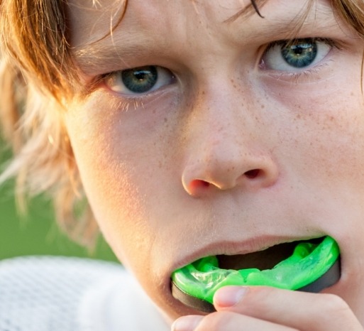 Closeup of teen placing custom athletic mouthguard