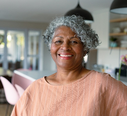 Senior woman at home standing and smiling