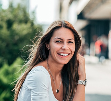 Woman with beautiful smile sitting outside in city