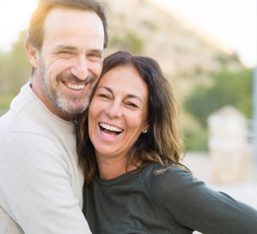 Man and woman with dental implants smiling