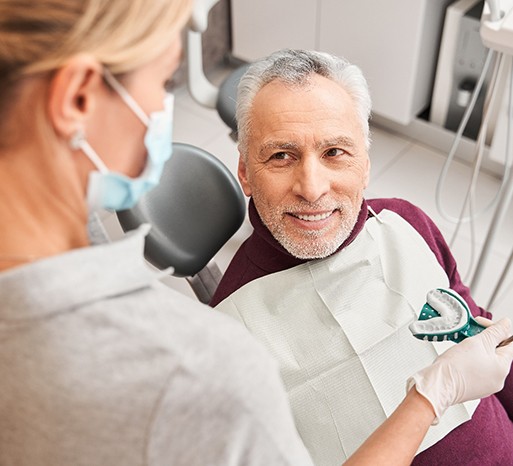 A dentist presenting her patient with dental impressions for dentures