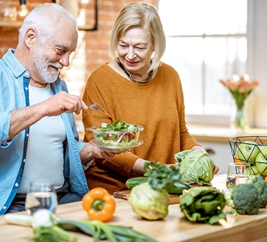 A happy senior couple making salads