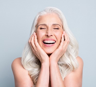 A pretty gray-haired lady enjoying her dental implants