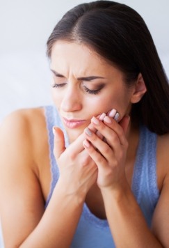 Woman holding the side of her jaw in pain