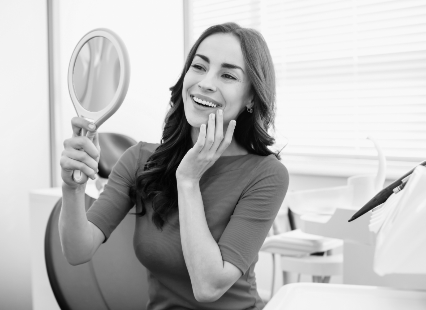 Woman looking at smile after inlays and onlays