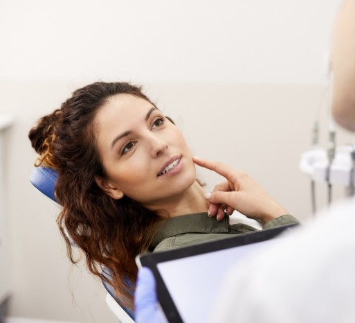 Woman pointing at smile before dental inlay and onlay treatment