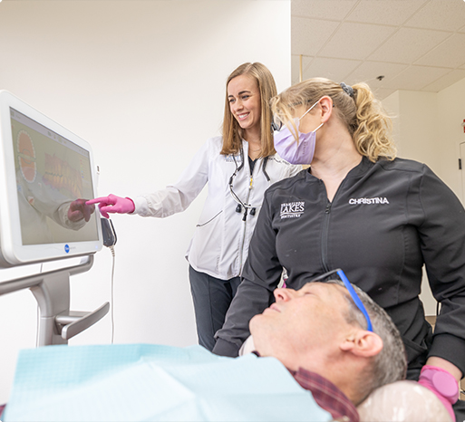 Dentist dentistry team member and dental patient looking at iTero digital impressions