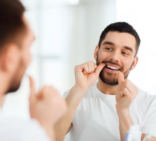 Man looking at healthy smile after treating tooth decay