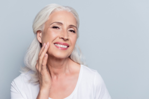 an older patient smiling after receiving cosmetic dentistry 